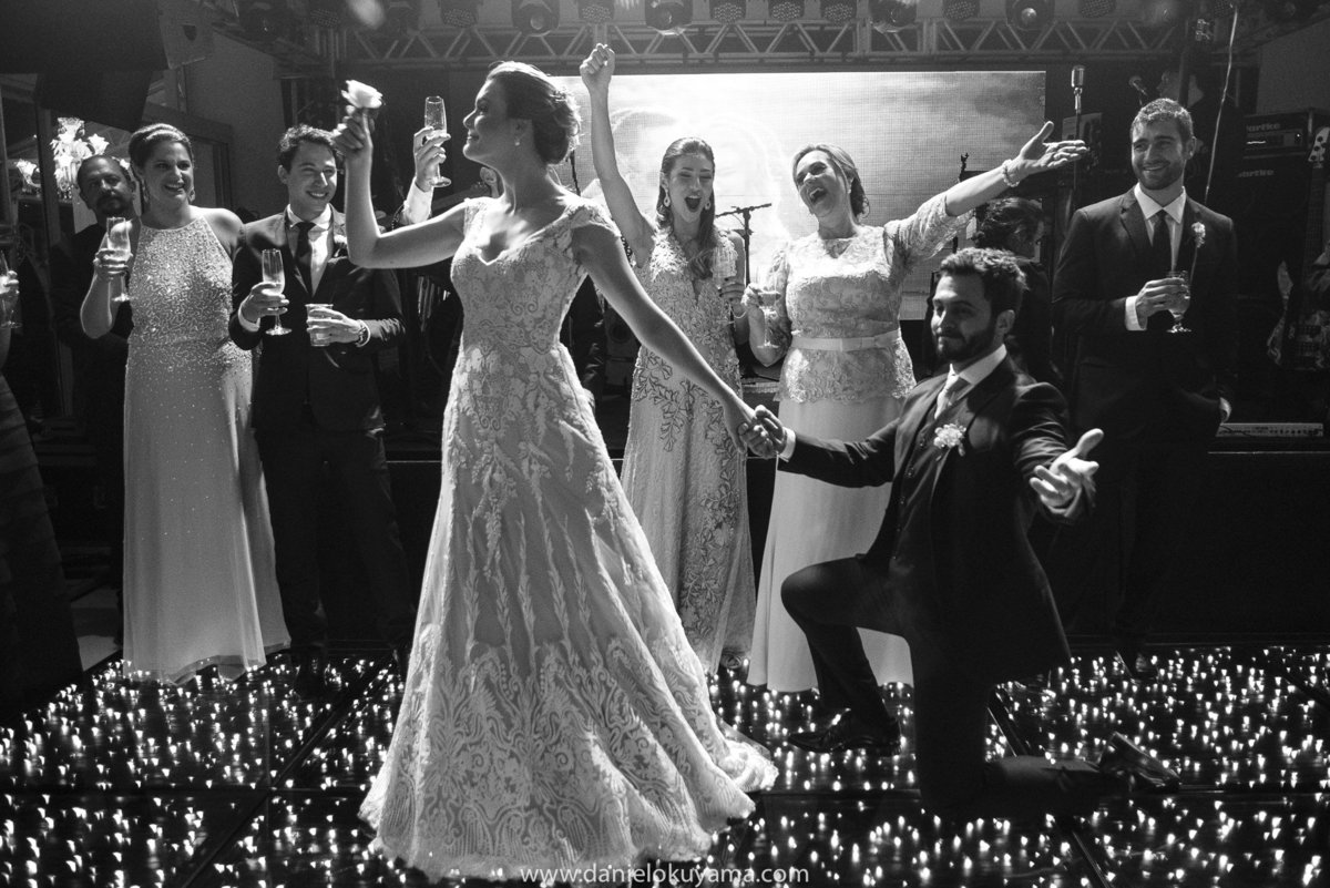 o noivo dançando feliz e a noiva plena em seu lindo vestido de noiva durante a festa de casamento 