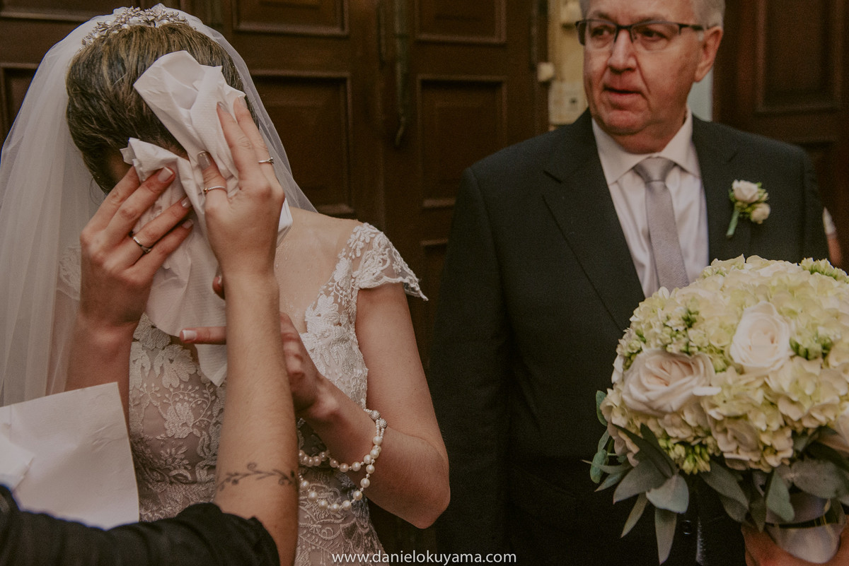 as assessoras ajudando a noiva se secar para a grande entrada do casamento