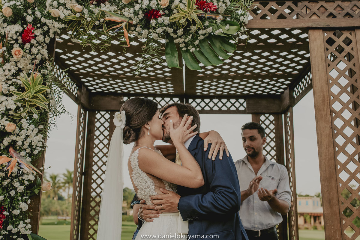 o beijo dos noivos com muito amor para celebrar a união em um belo dia no Golf Clube do Guarujá