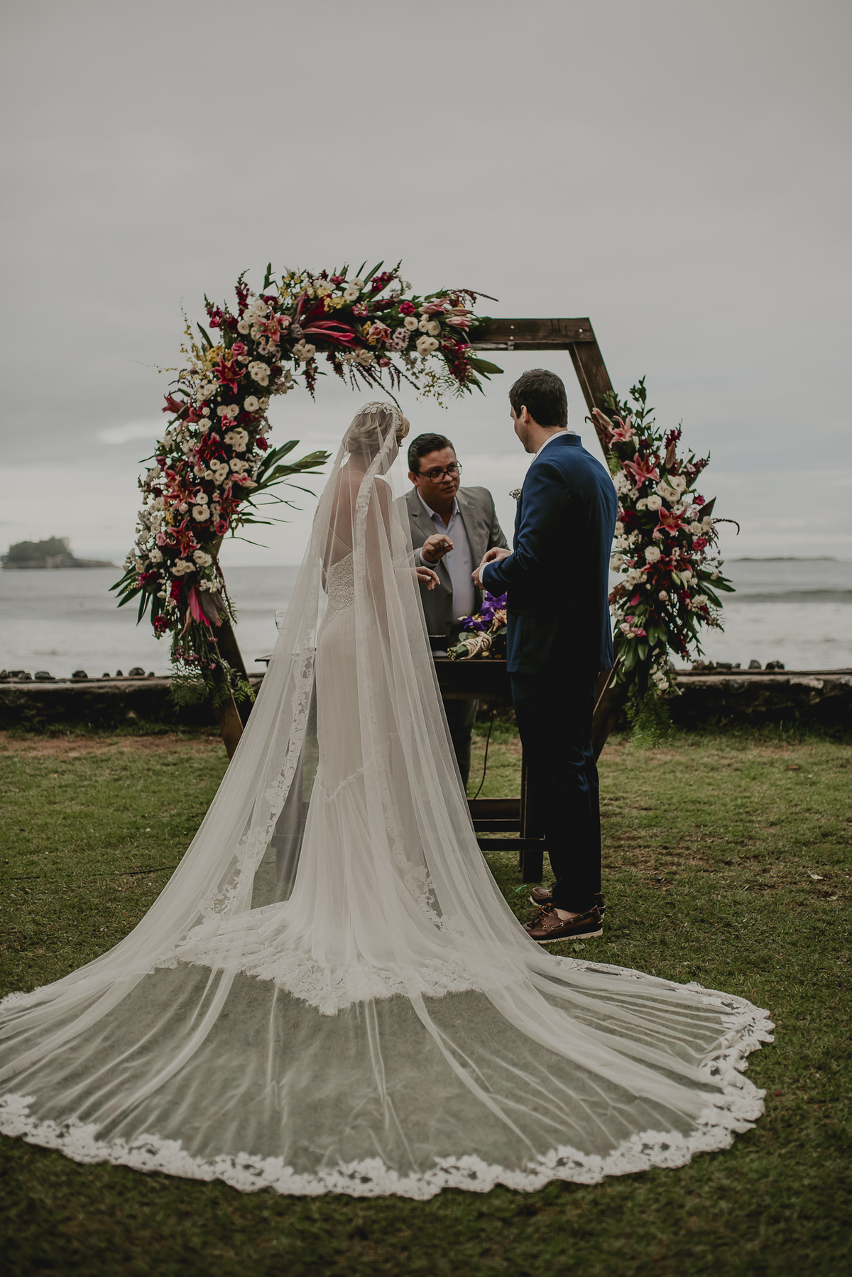 a fotografia do momento da troca de alianças dos noivos que se casaram em uma linda cerimonia na praia do litoral de sp com a fotografia mais espontânea e divertida do melhor fotografo de casamentos de sp