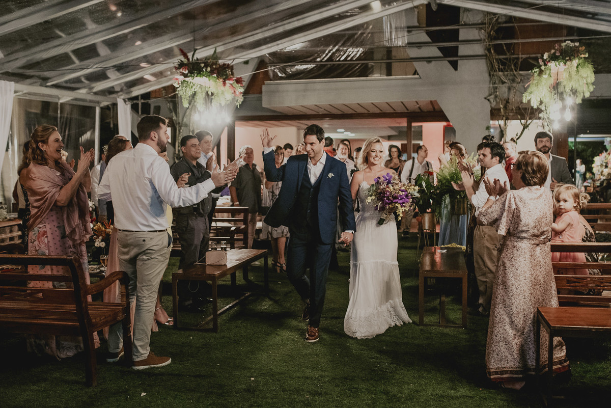 a entrada dos noivos na festa de casamento durante recepção de convidados na fotografia de casamento sp