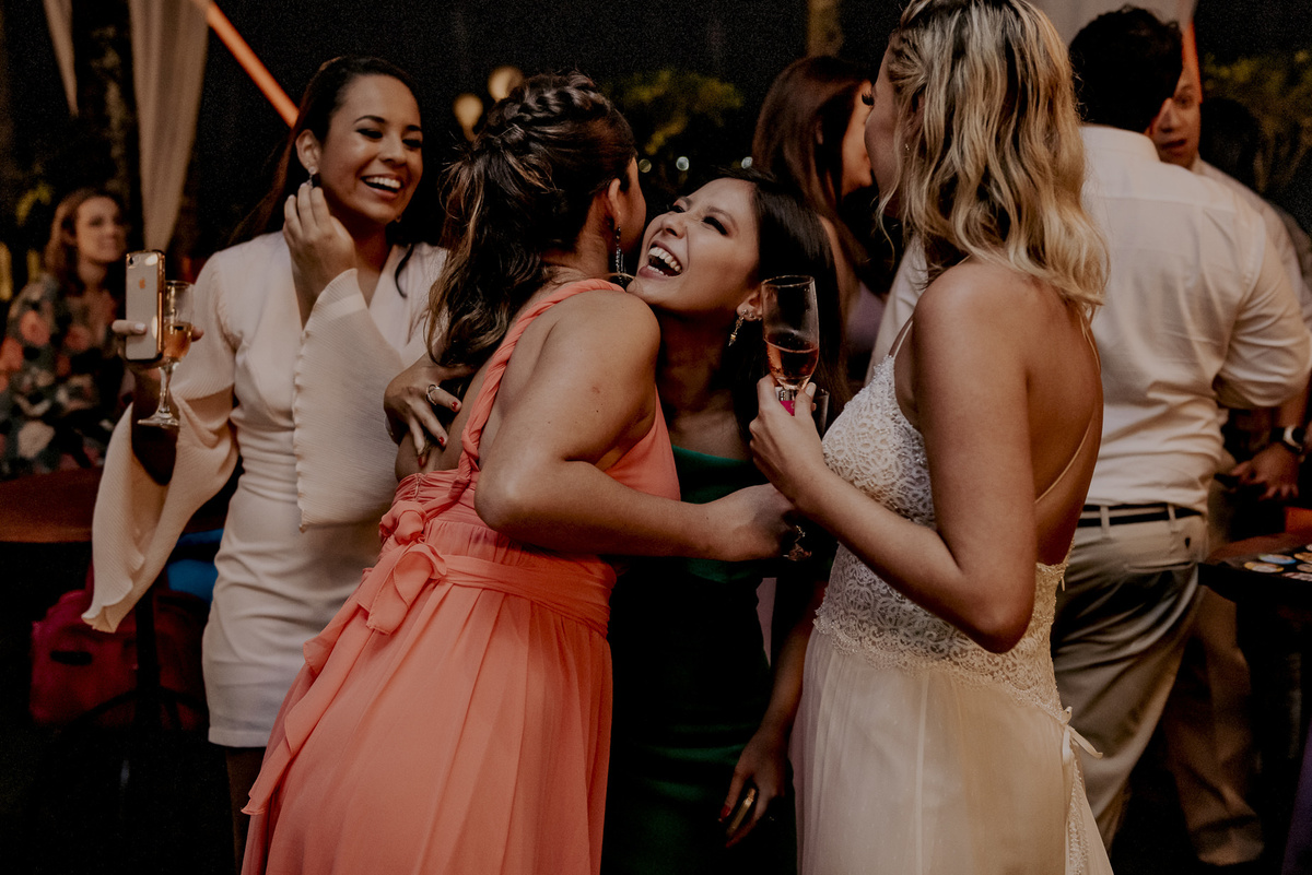 as fotografias de abraços e sorrisos dos noivos com seus convidados ´´uma forma de agradecimento pelo casamento na praia cheio de amigos e de personalidade do casal de noivos durante a festa de casamento na praia no litoral de sp