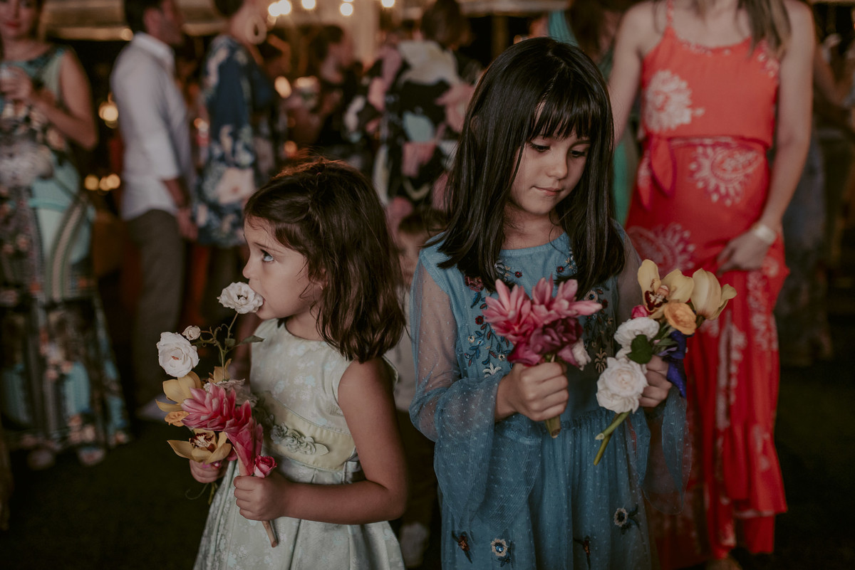 as crianças apaixonadas pelas cores das flores desse lindo casamento na praia lindamente registrado pelo fotografo de casamento daniel okuyama