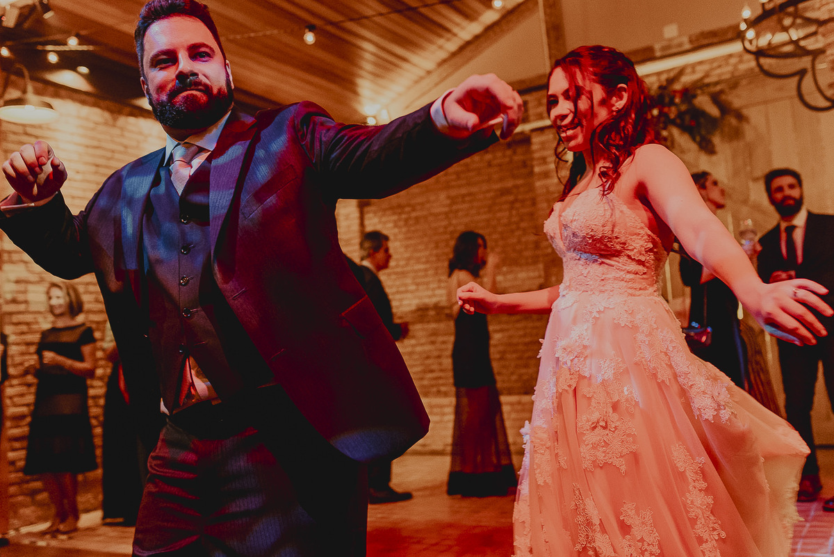 os noivos dancando e se divertindo durante a festa de casamento em espaco mais rustico com musica animada, bebendo e curtindo muito a balada de casamento.