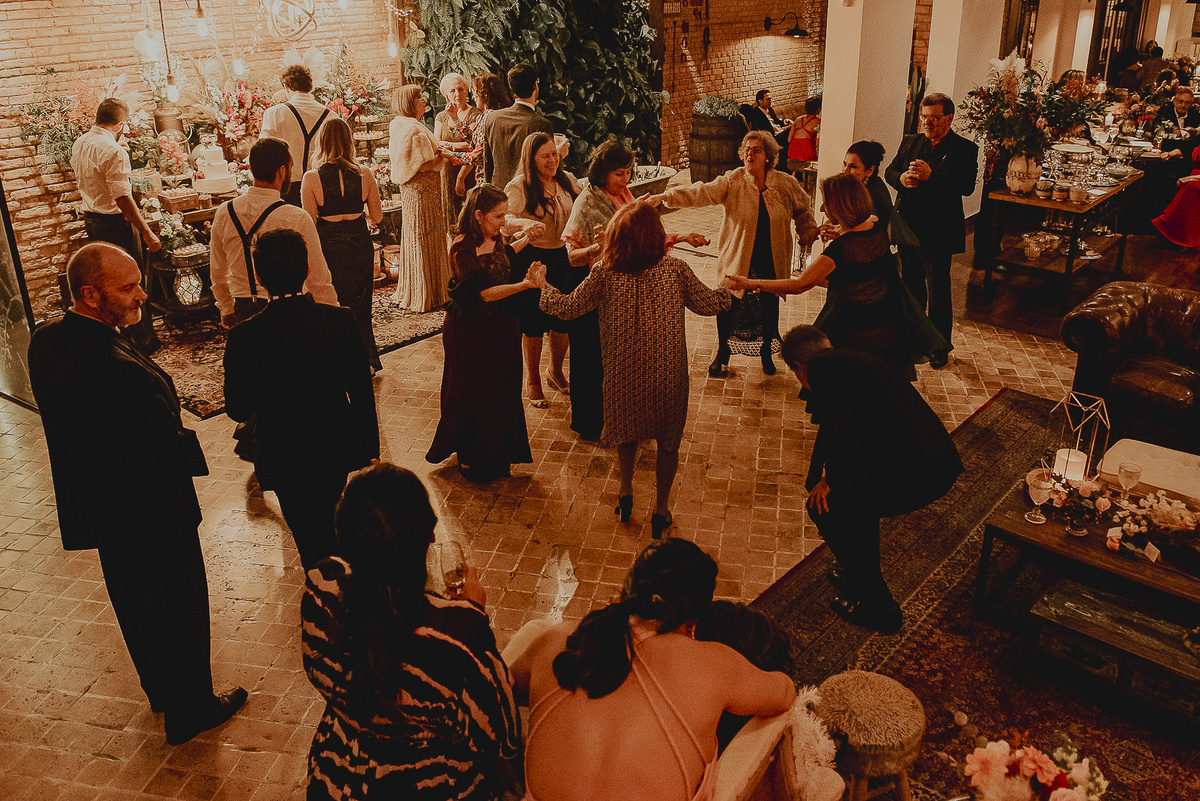 uma fotografia mais aberta de todos o convidados do casamento, mostrando muito bem a decoração e a essência rústica do espaco celeiro quintal 