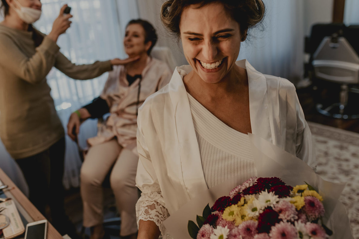 noiva com seu buque durante a maquiagem