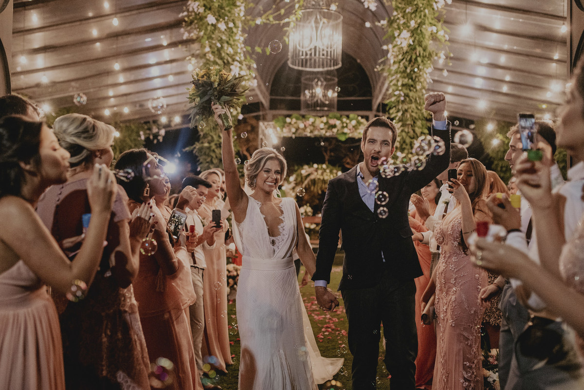 a alegria e a espontaneidade na saída dos noivos ao final da cerimonia de casamento no villa sansu foto de daniel okuyama fotografia