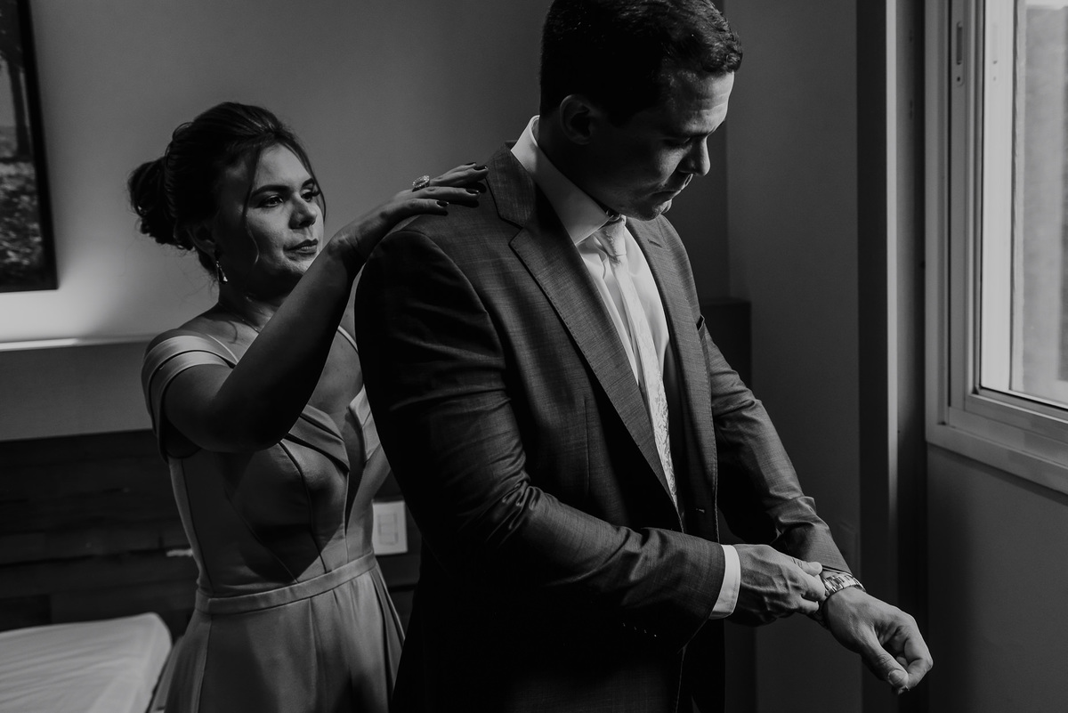 fotografia espontanea do noivo com sua mãe ajudando a ajeitar seu traje de noivo minutos antes de começar a cerimonia de casamento foto de daniel okuyama fotografia