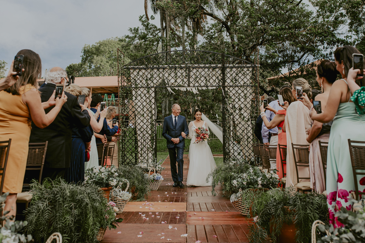a tão esperada chegada da noiva com seu pai a caminho do altar, onde o noivo a espera emocionado, um lindo casamento do campo. lugar para casar no campo