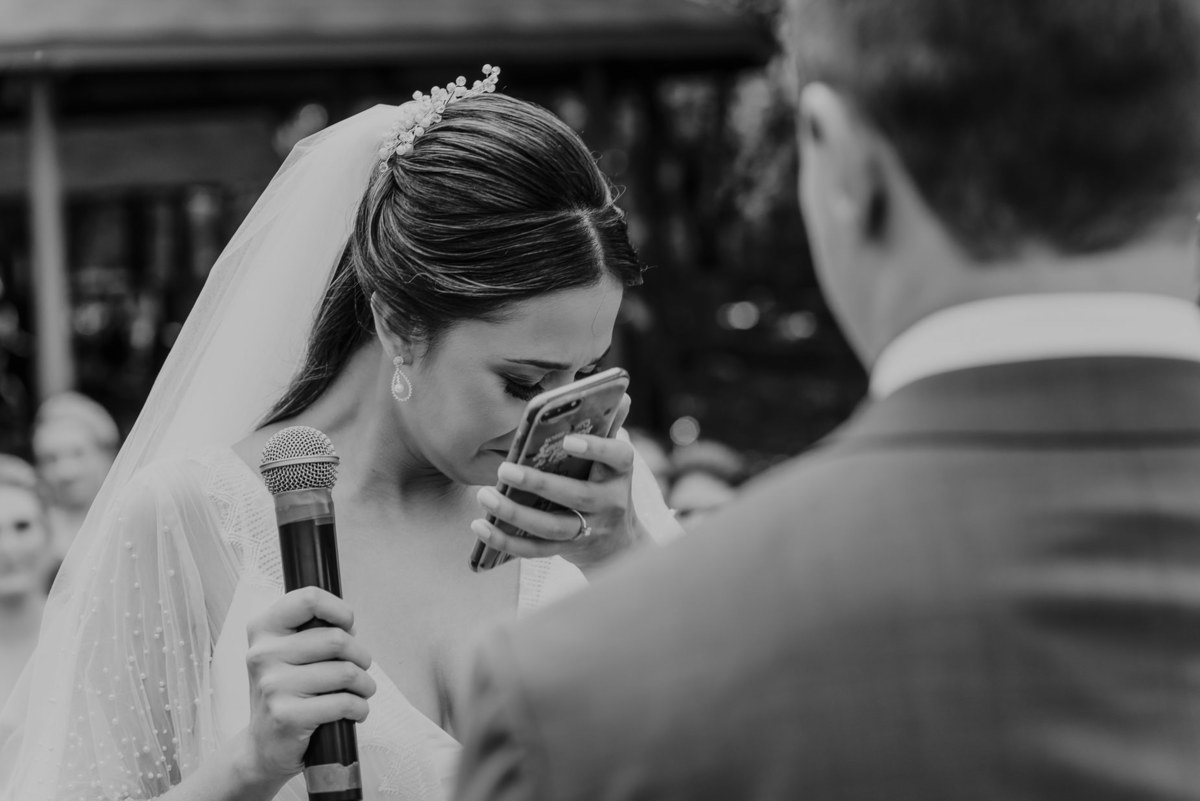 o momento da leitura dos votos é sempre muito emocionante e rende boas fotos. A noiva ao ler seu voto para o noivo não consegue conter a emoção, deixando todos os convidados emocionados uma foto perfeita de casamento ao ar livre