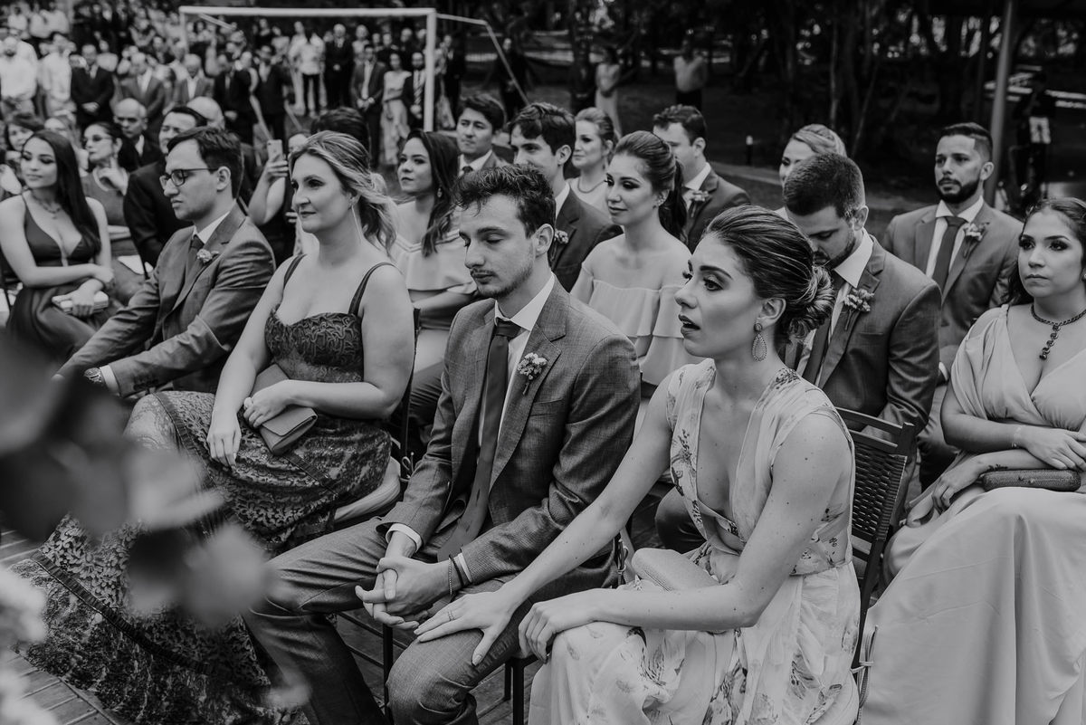 os padrinhos e as madrinhas emocionados durante os votos da cerimonia do casamento ao ar livre no campo