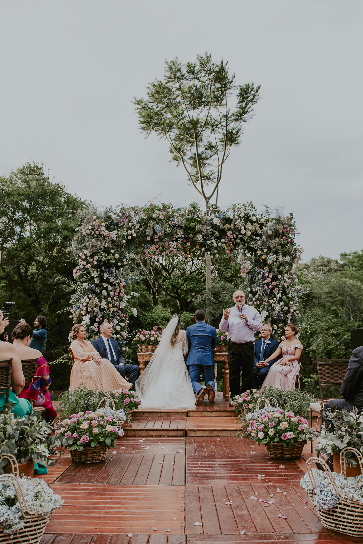 decoração do altar no casamento na fazenda ao ar livre durante celebração da cerimonia a noiva e o noivo recebendo a benção pelo seu casamento 