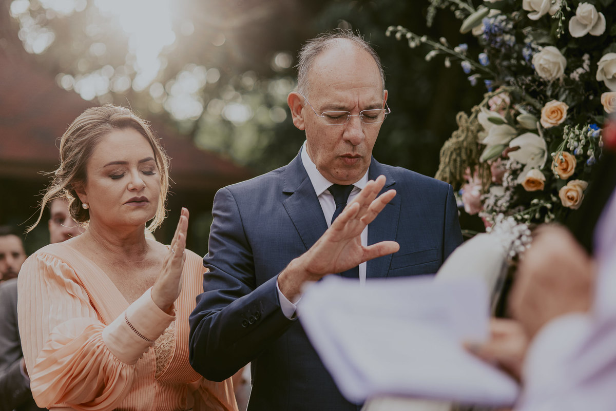 os pais da noiva abençoando o casamento da sua filha com muito amor e felicidade e o sol lindo para um casamento ao ar livre