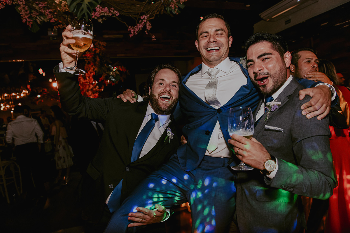 os padrinhos e amigos do noivo muito animado na festa de casamento do amigo. sorrisos de felicidade estampado no rosto de cada um