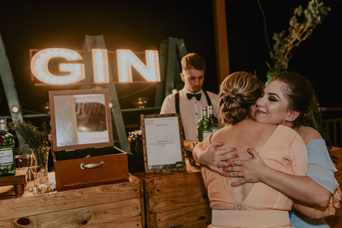 na festa de casamento deve ter gin e os convidados vão adorar o abraço em frente ao bar do casamento que aconteceu ao ar livre e depois a festa foi animada. registro do daniel okuyama