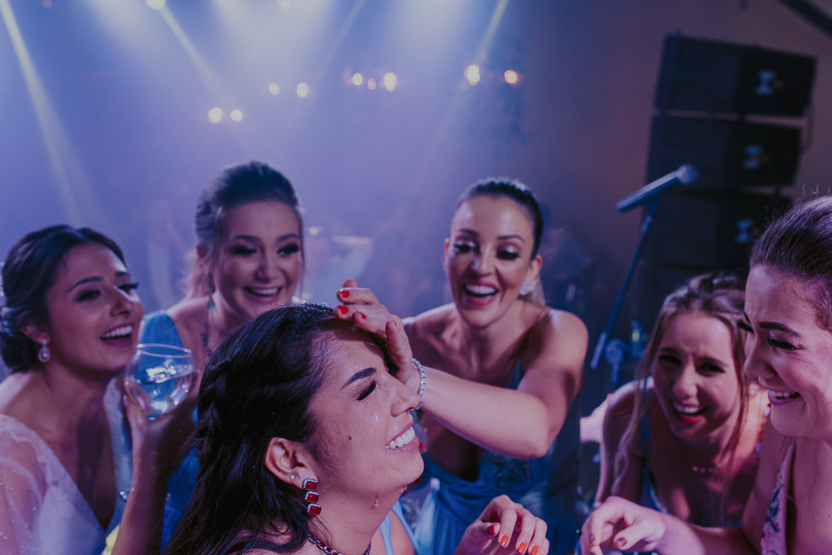 as madrinhas brindando e dançando muito na pista de dança da festa do casamento em fotos inusitadas e divertidas do casamento mais animado. fotografia de casamento espontanea é com o daniel okuyama fotografia que explora a verdade em suas imagens 