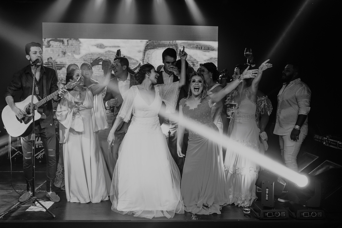 fotografia documental de casamento, noiva e madrinhas no palco aproveitando o casamento dançando se divertindo com muita animação, fotos espontâneas da festa do casamento pelo melhor fotografo de casamento daniel okuyama