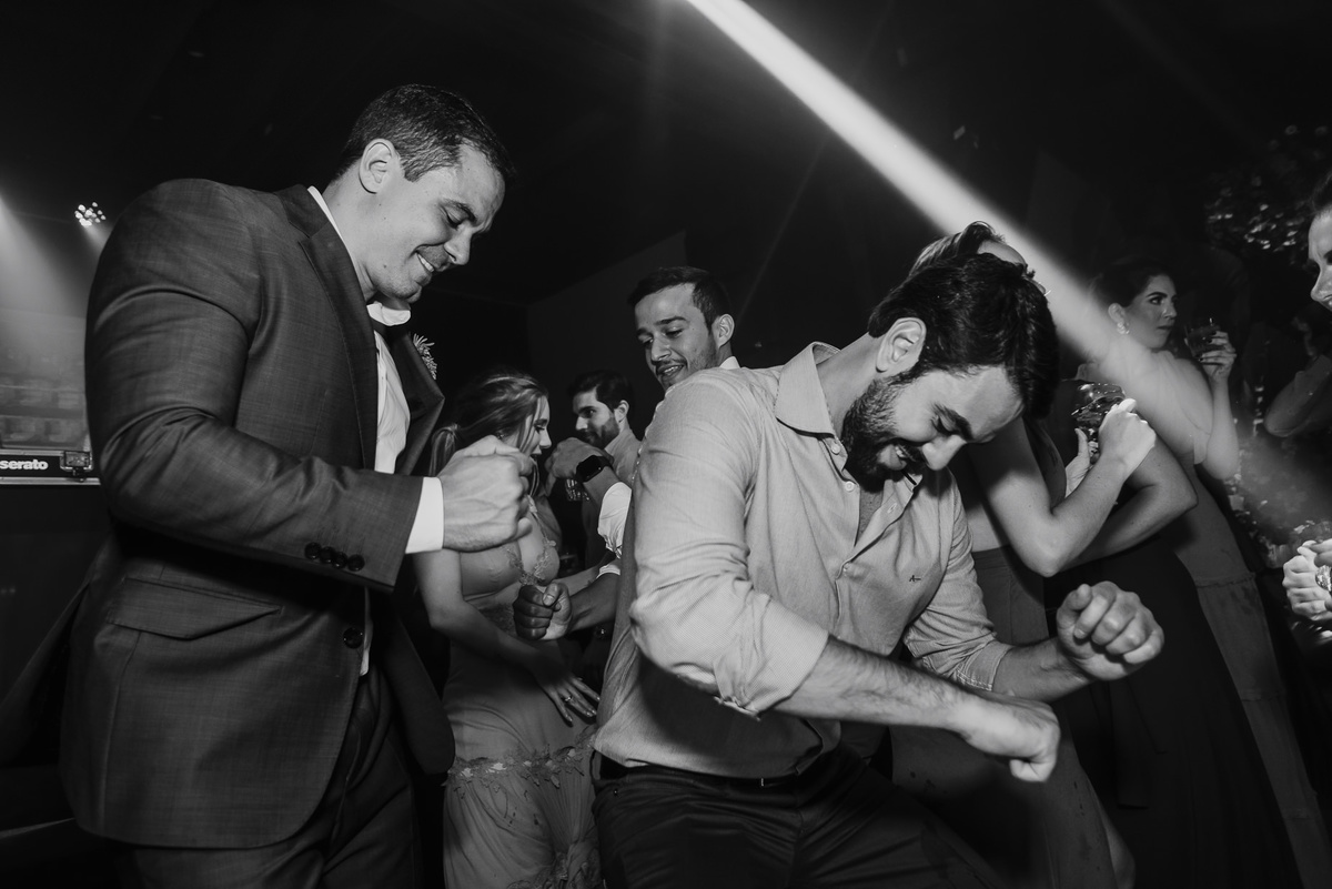 os convidados se divertem muito em uma fotografia mais que animada do daniel okuyama transmitindo alegria e animação na festa do casamento