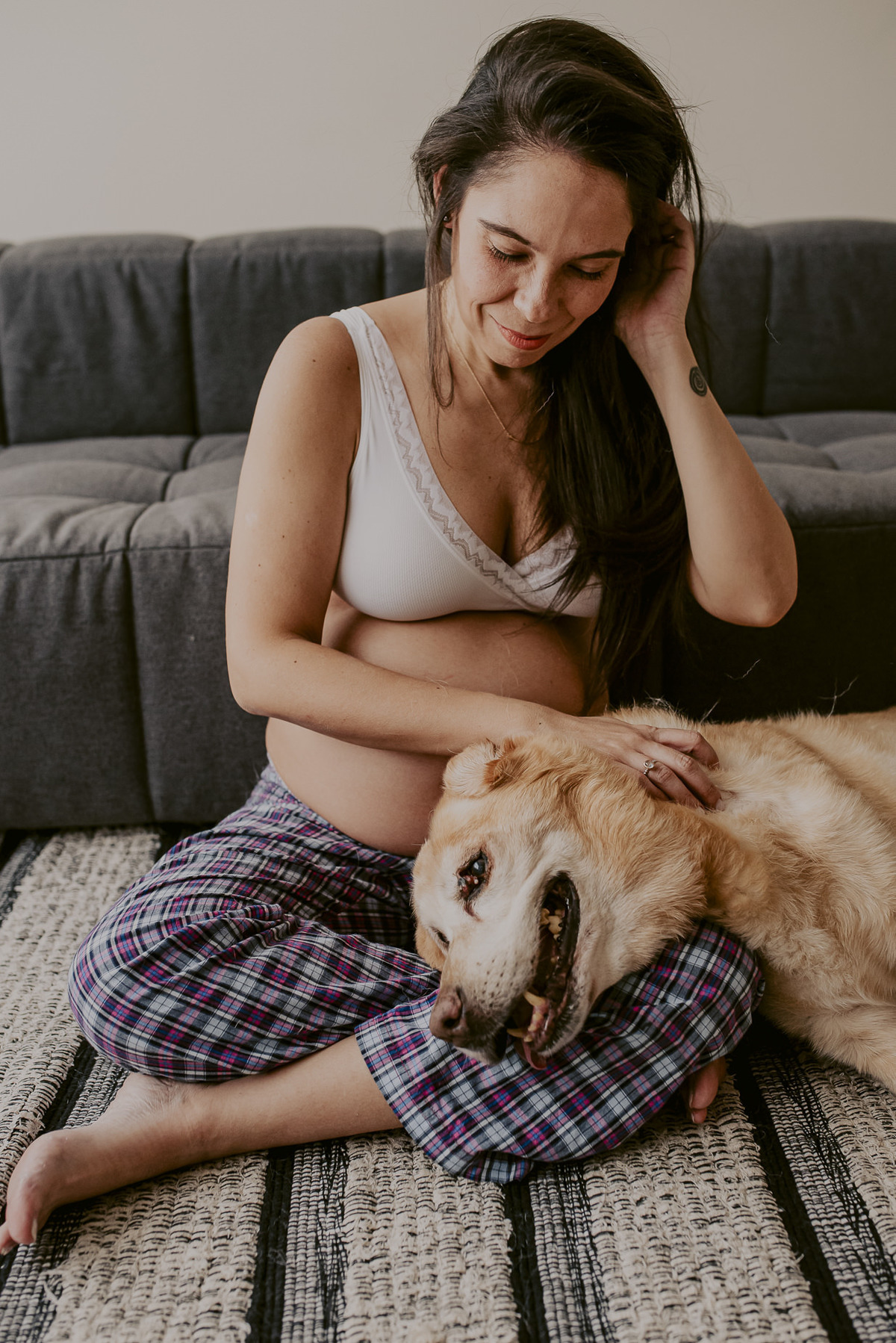 cachorro com a barriga de gravida em ensaio emocionante da gestante em seu apartamento em casa São Paulo pelo melhor fotógrafo. Fotos feitas durante quarentena com segurança covid-19 pandemia