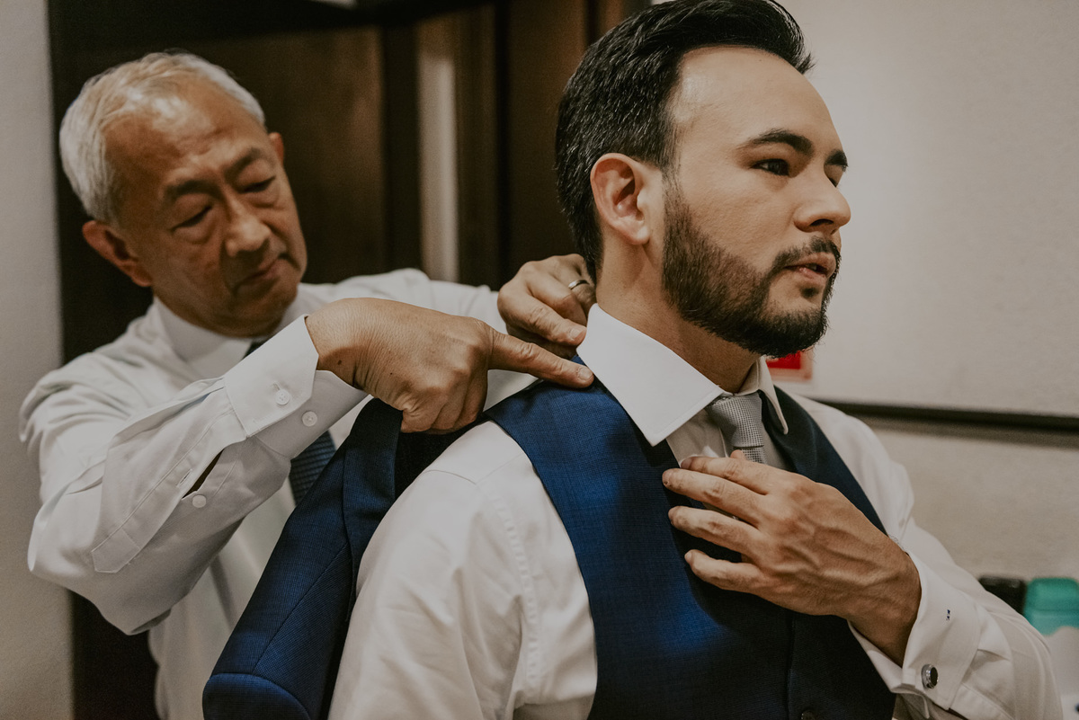 o pai do noivo carinhoso arrumando a gola da camisa 