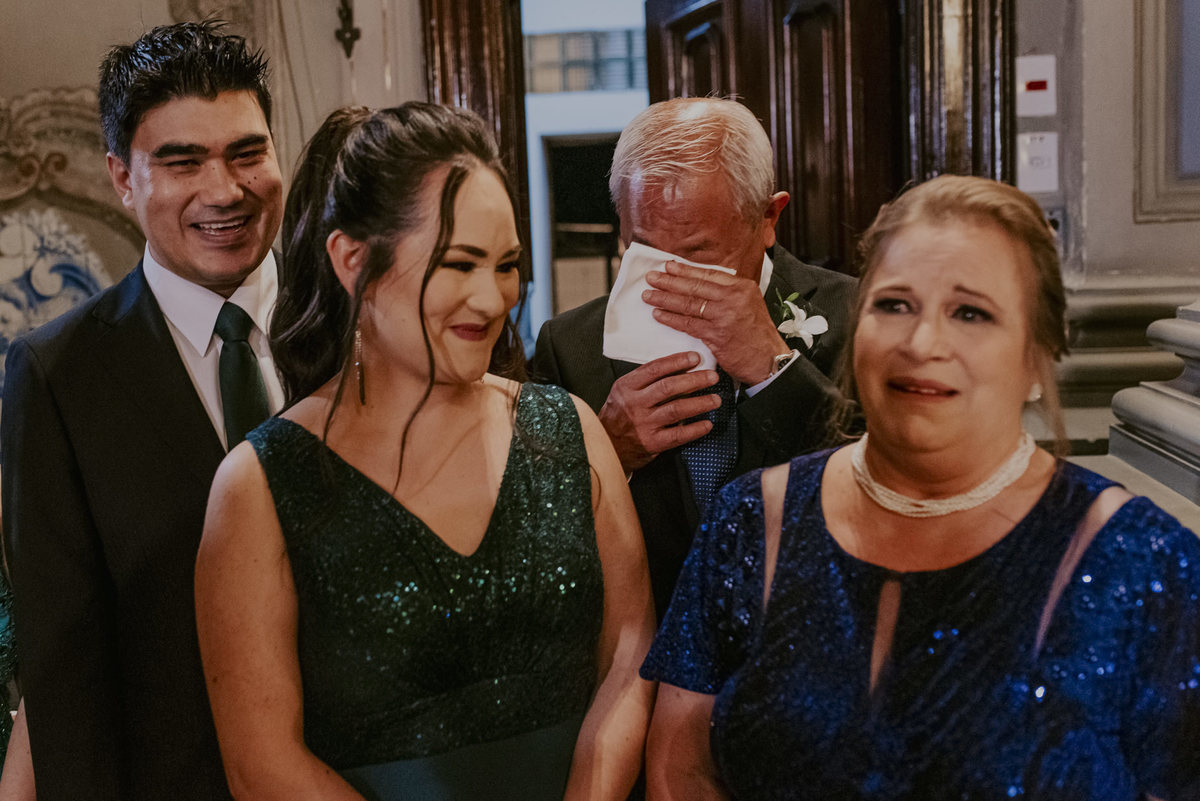 os convidados e o pai do noivo muito emocionados a espera da grande hora que é a entrada da noiva no casamento