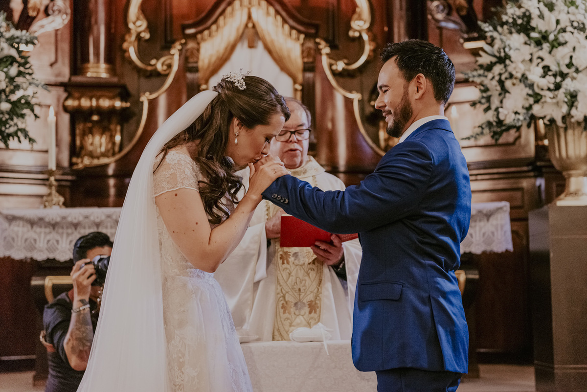 o beijo da noiva na aliança do noivo na cerimonia de csamento capela da puc sp