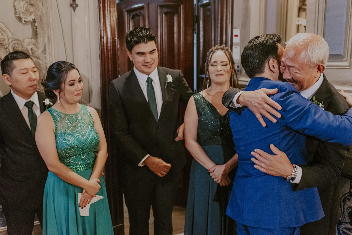 ao abraçar o pai na igreja o noivo se emociona demais tendo esse belo registro espontâneo da fotografia documental de casamento pelo melhor fotografo daniel okuyama 