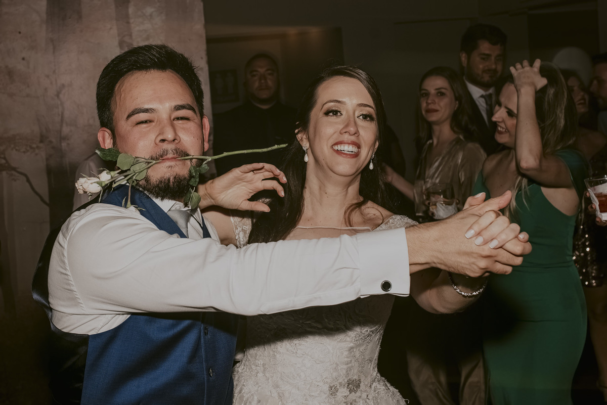 o noivo com uma flor na boca dançando tango com a noiva na festa do casamento, muita alegria diversão daniel okuyama fotografo de casamento sp tirou a melhor foto de casamento