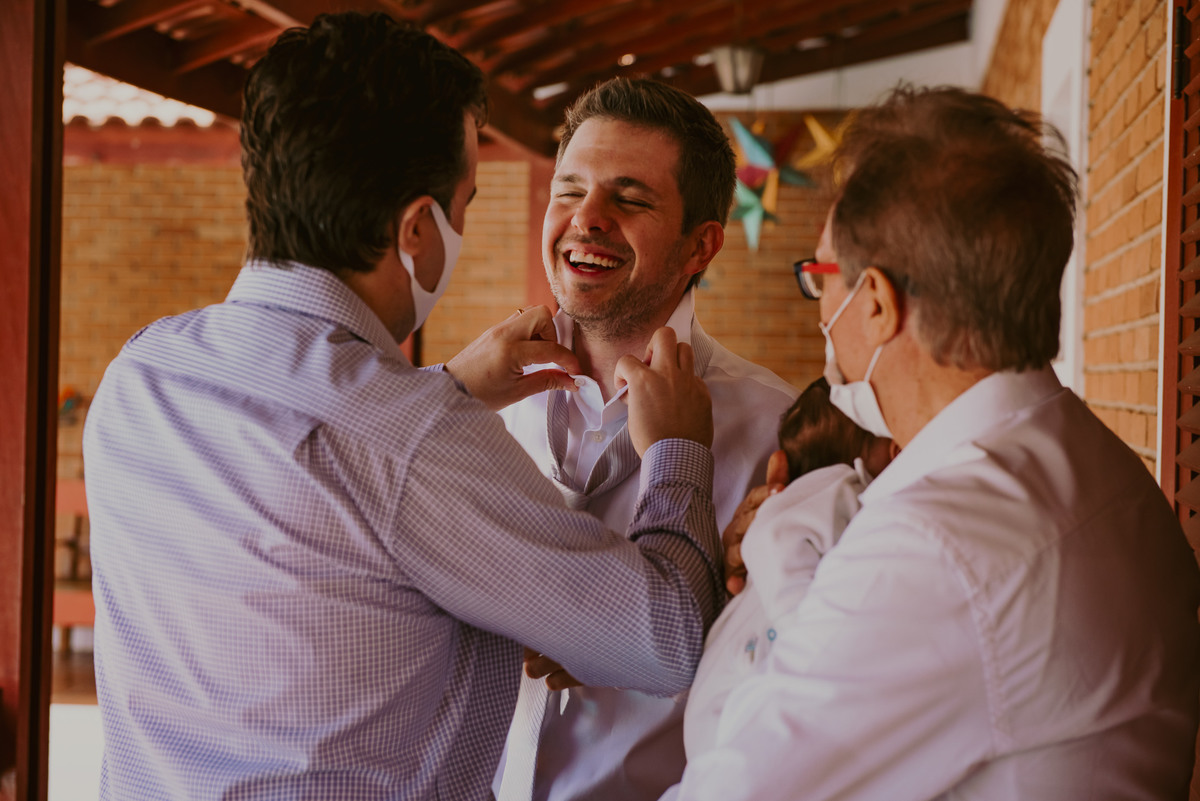 o noivo junto com seu pai se arrumando na sala do noivo em casamento celebrado na fazenda ao ar livre