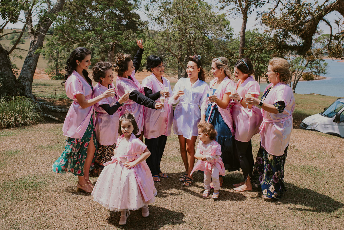 um brinde com as madrinhas e a daminha da noiva comemorando ao ar livre foto inspiração  