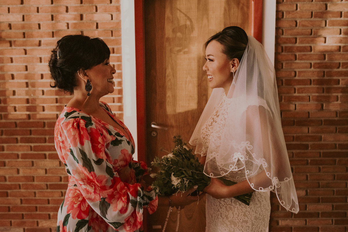 a noiva com sua mae se preparando para a grande entrada antes da cerimonia de casamento