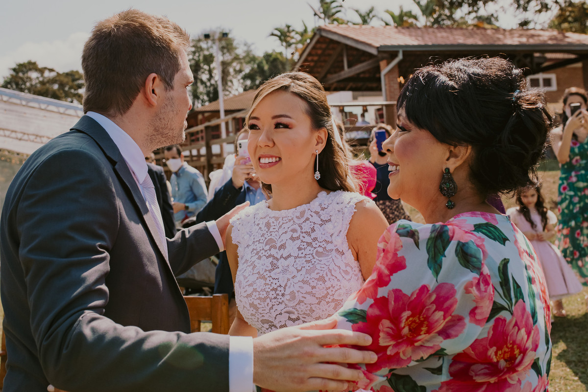 o noivo recebe a noiva com todo carinho em um casamento realizado no sitio a céu aberto com uma decoração 