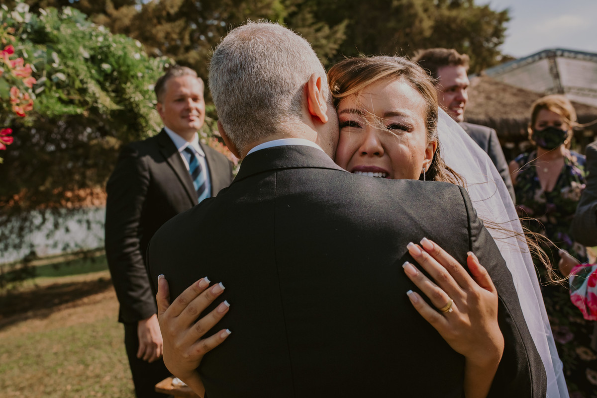 a fotografia registra o abraço de cumprimentos dos noivos