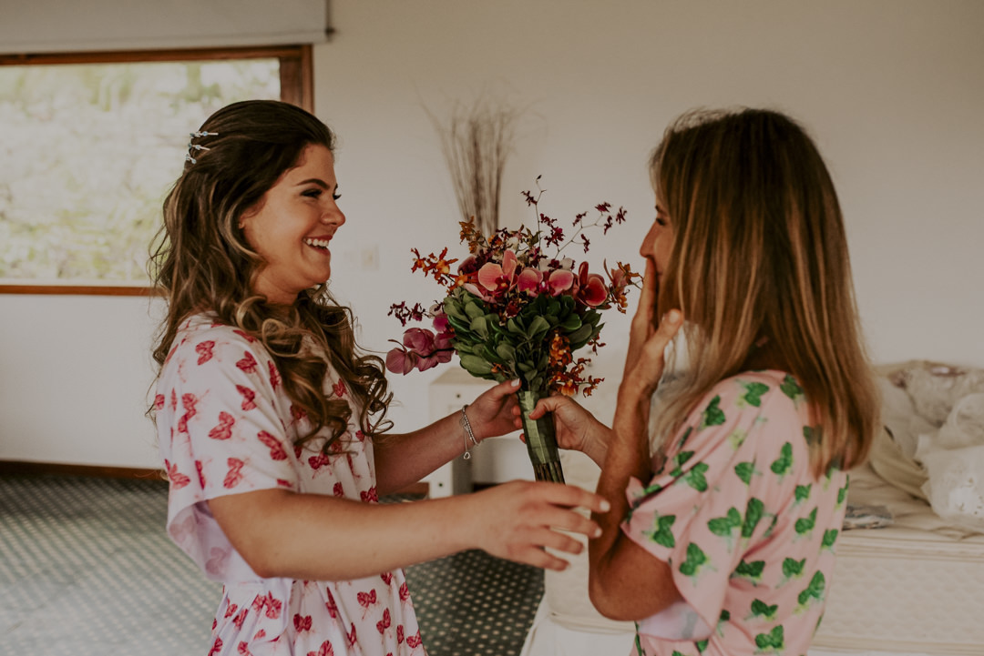 mãe entregando o buque para a noiva no making of casamento na praia casamento em toque toque pequeno reserva tambá casamento pé na areia casamento litoral norte