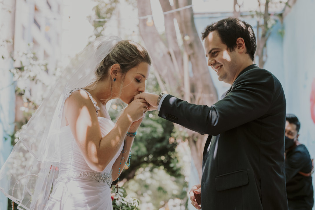 a noiva beija a mão do noivo com aliança 