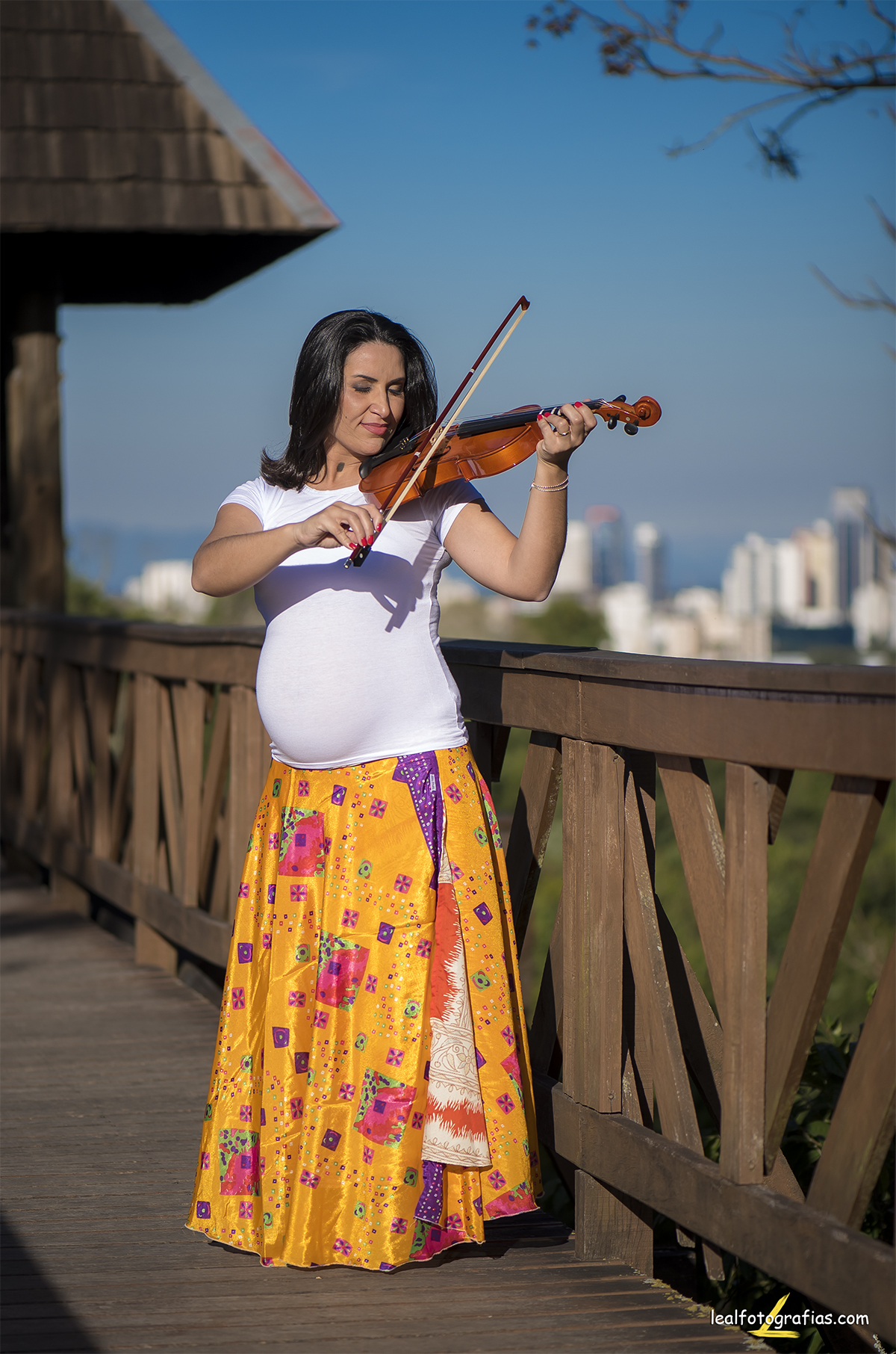 ensaio de gestante tocando violino na passarela do bosque do alemão em curitiba