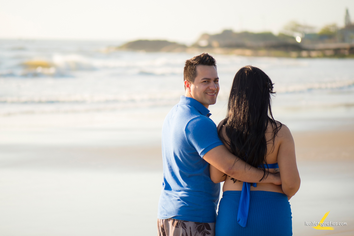 papai e mamãe caminhando na praia em ensaio gestante