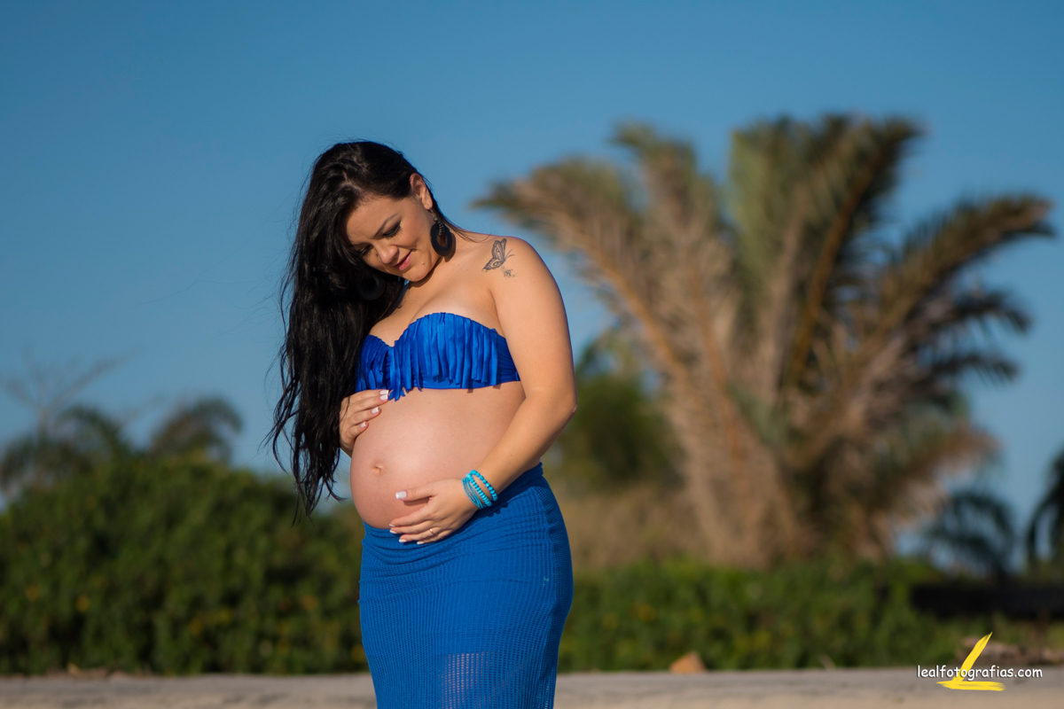 linda gestante com vestido azul na praia de itapoá