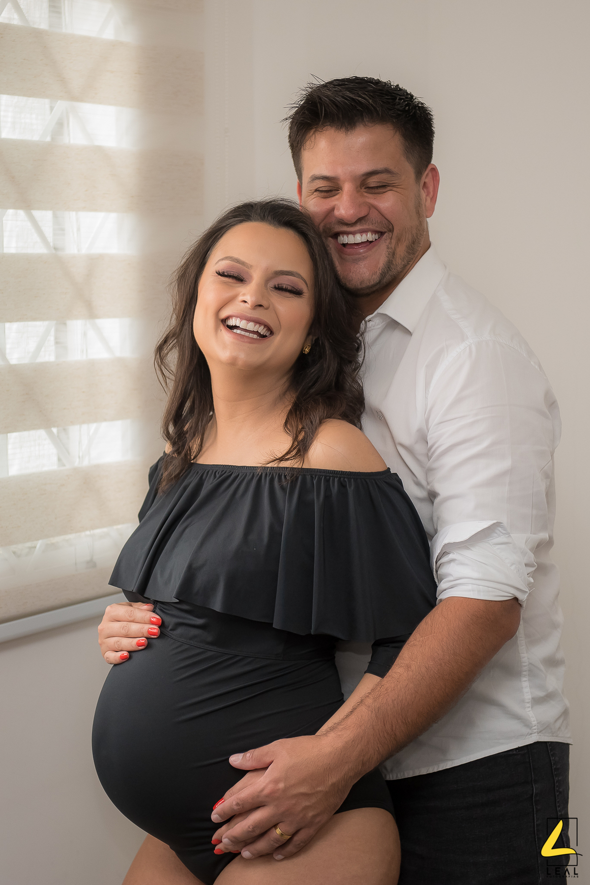 casal sorrindo com luz da janela por fotógrafo rodrigo leal