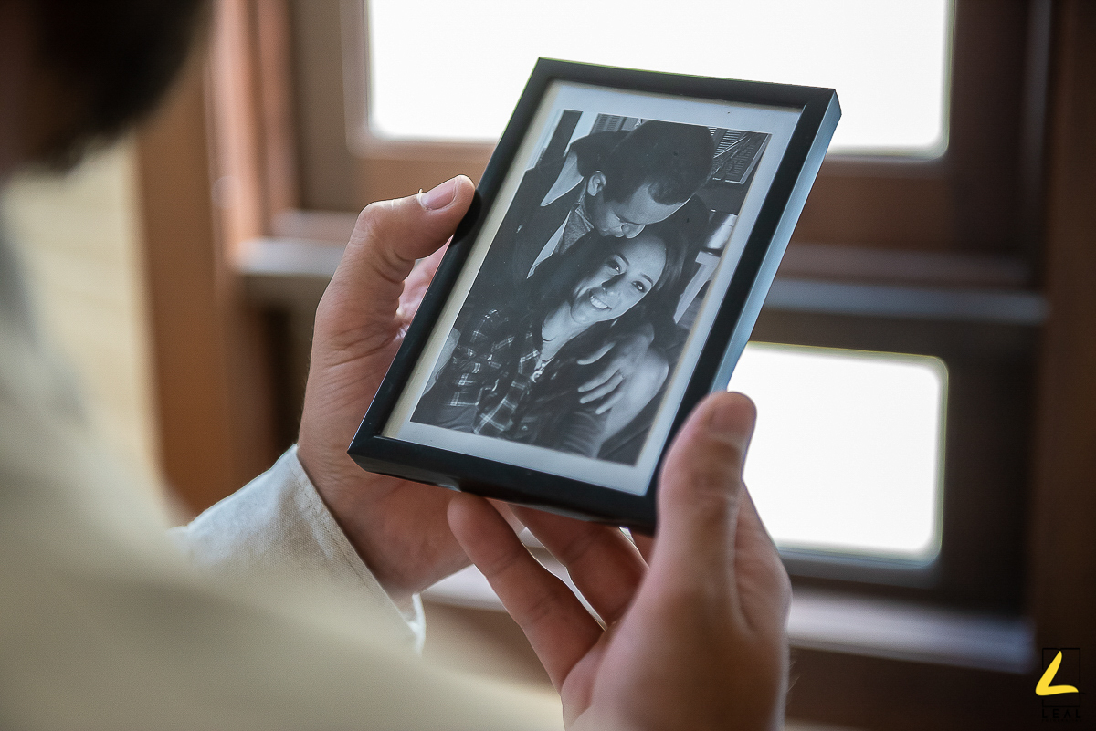 Noivo olhando o retrato da noiva em making of por Leal Fotografias em Guaratuba