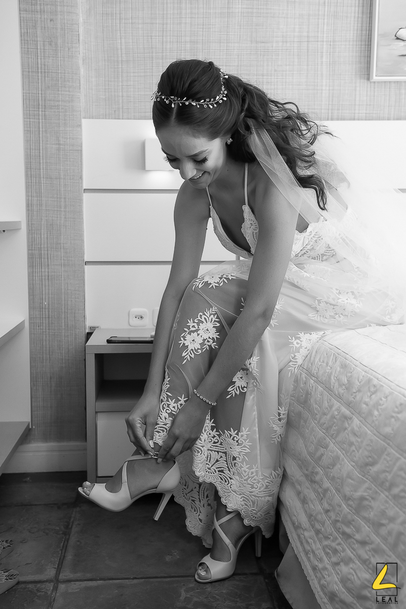 Noiva arrumando o sapato em ensaio antes do casamento