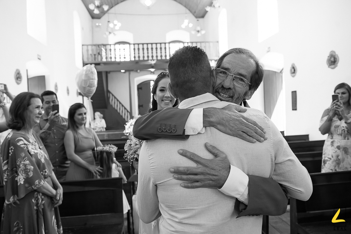 Pai abraçando o genro em foto preto e branco por Rodrigo Leal