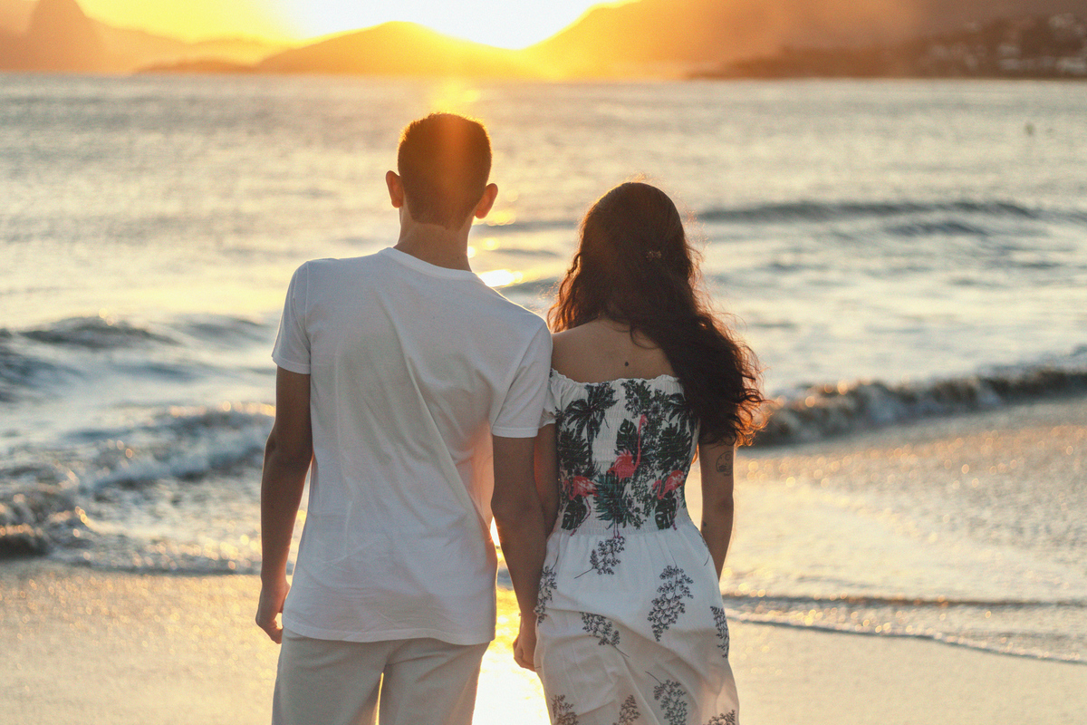 casal apreciando o pôr do sol na praia de Itaipu