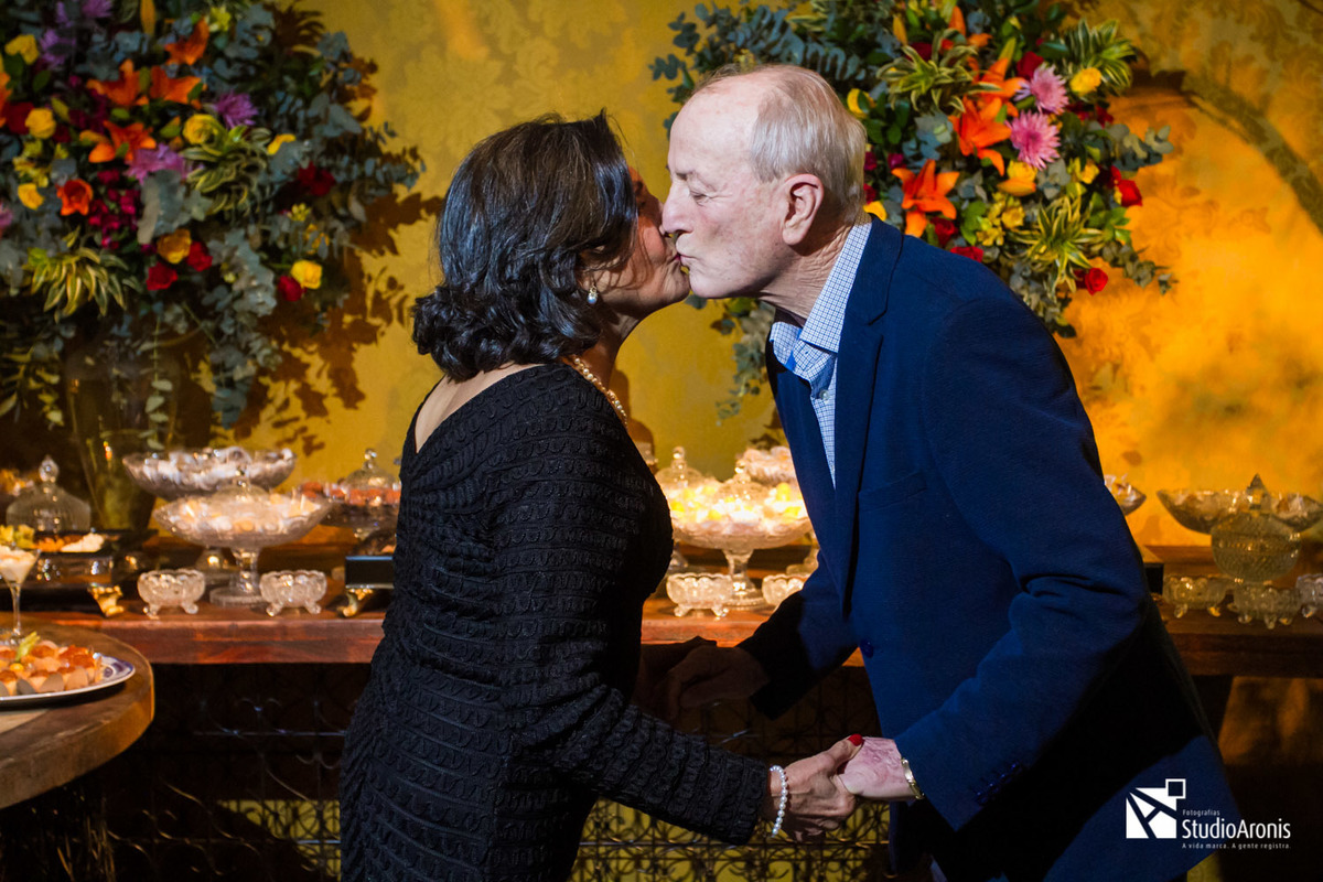 Aniversário de 80 anos - Foto do casal em frente a mesa de doces - decoração com papel de parede - revestimento - cerimonial julio cardoso - gremio nautico união - praça dos fundadores - gnu