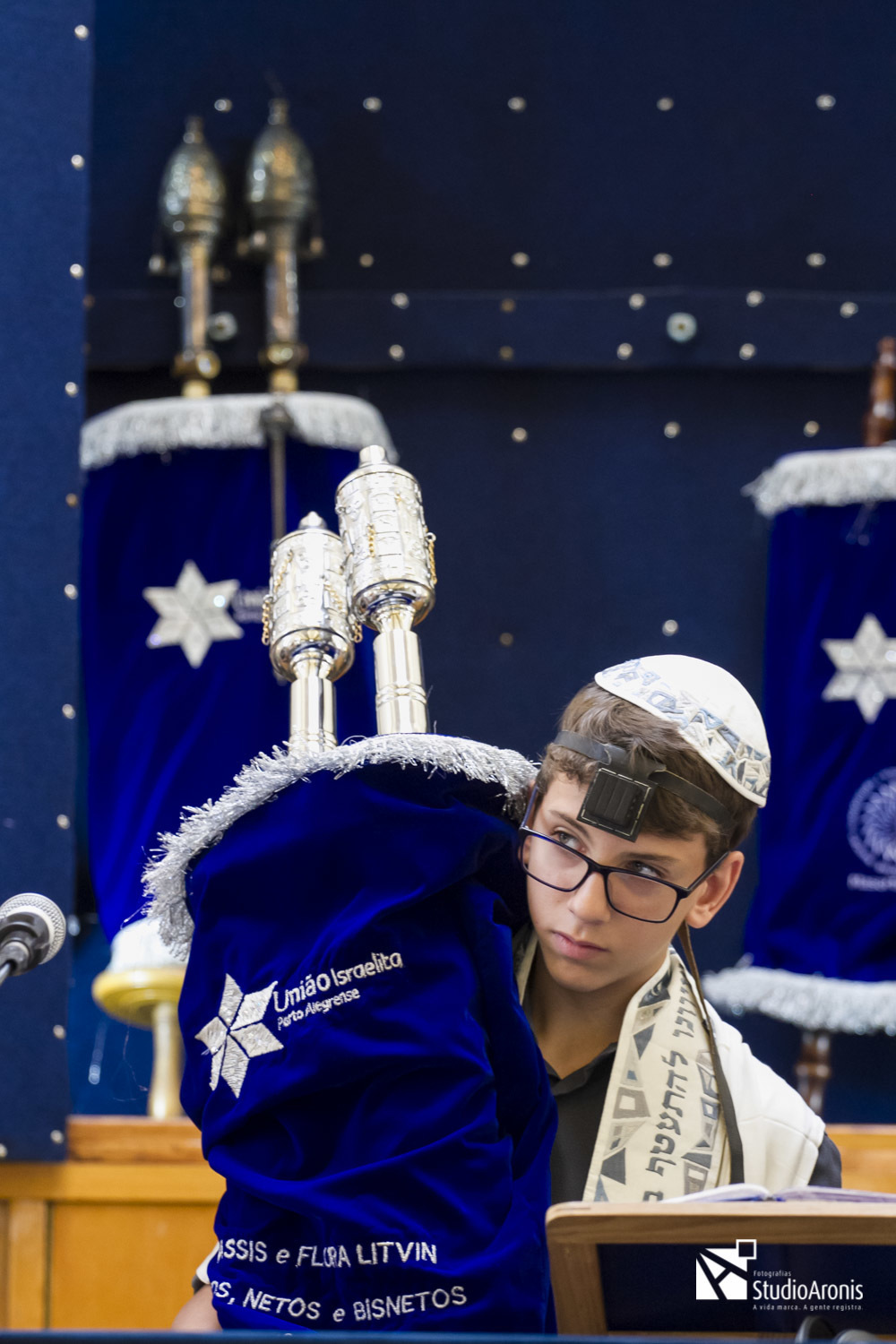 menino levando a torá em seu bar mitzvah na sinagoga