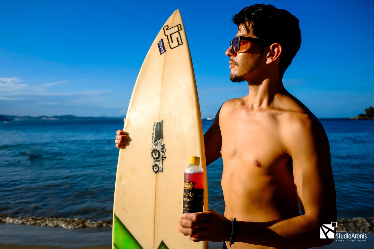 Fotografia de Produtos - Kombuchas - Espumante da Saúde - Balneário Camboriú - Santa Catarina - Prancha de Surf - praia - mar - foto conceito - areia - taça - espumante - fotos com estilo - modelo - studio aronis fotografias - sol