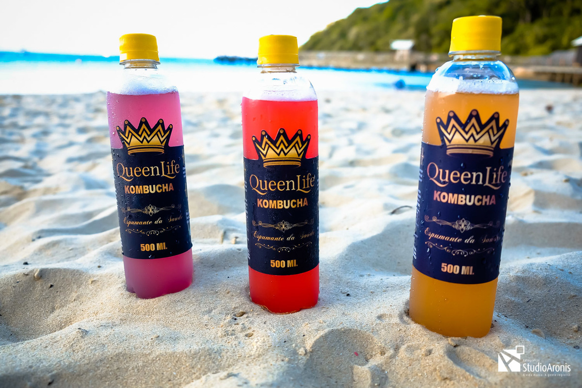 Fotos de produtos criativas - kombuchas queenlife - espumante da saúde - praia mar sol areia sabores cores