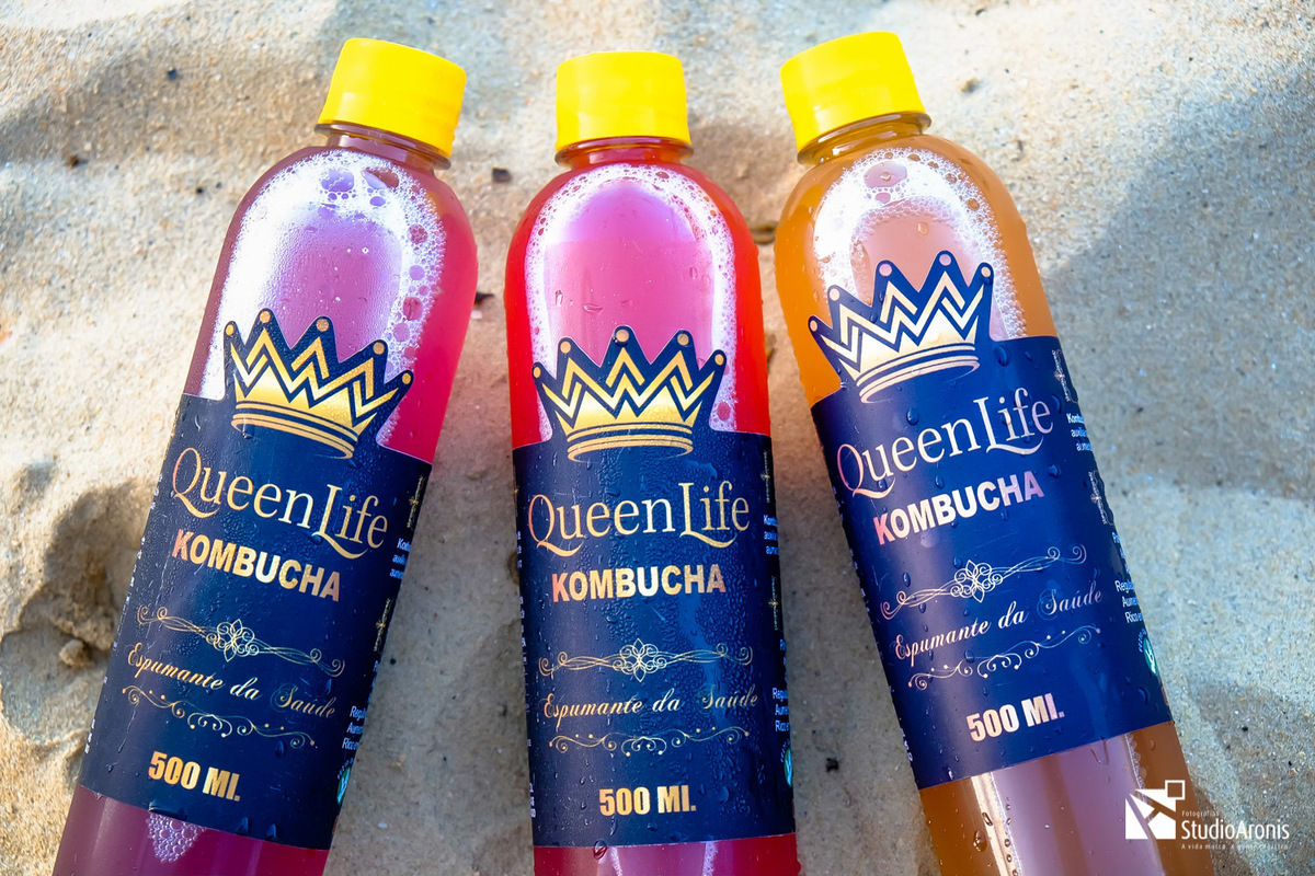 Fotos de produtos criativas - kombuchas queenlife - espumante da saúde - praia mar sol areia sabores cores