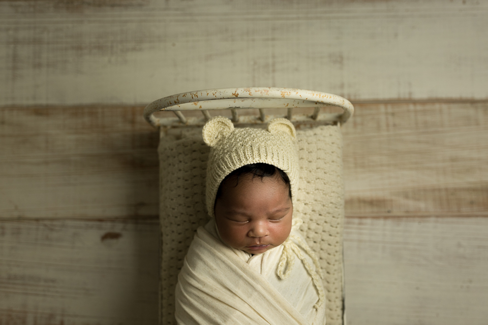 newborn fotografado com luz contínua usando touquinha da mimos de foto na caminha da love prop e manta da Michele Bandeira 