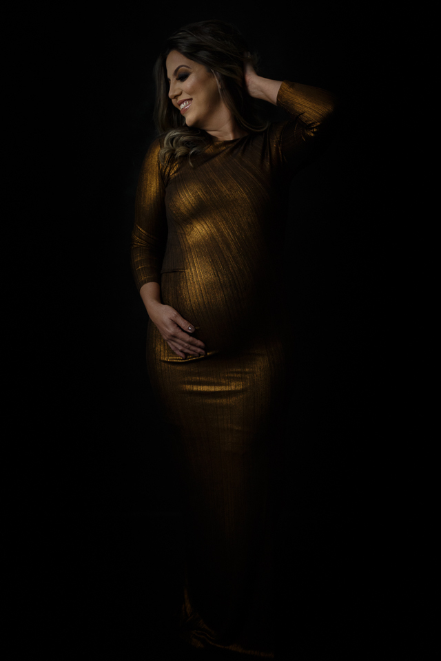 gestante no estudio kalila issa com luz contínua e fundo preto 